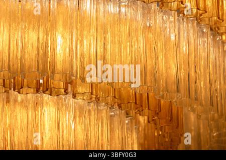 Élégant lustre photo macro avec des pièces en verre de couleur ambre, formant une pièce maîtresse d'éclairage sophistiquée et chaleureuse dans un ensemble intérieur luxueux Banque D'Images