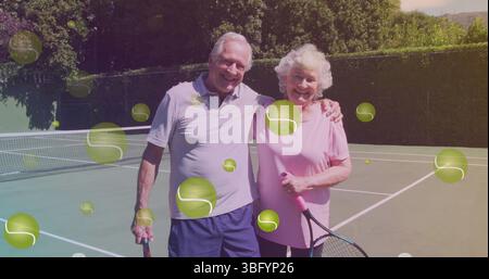 Image de balle de tennis tombant sur un couple de personnes âgées caucasiennes sur le court de tennis Banque D'Images