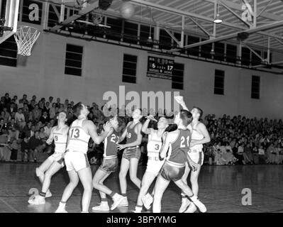 A.V. Shirk a capturé cette photographie de 1955 d'un match de basket-ball à Worthington High School. L'image illustre l'énergie et l'athlétisme des athlètes du secondaire lors d'un événement sportif local dans l'Ohio. Banque D'Images