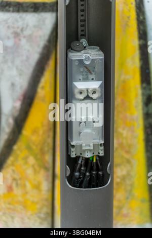 Un module de connexion ouvert à l'intérieur d'un lampadaire montre l'installation électrique en détail. La technologie est exposée, avec des câbles et des terminaisons visibles Banque D'Images