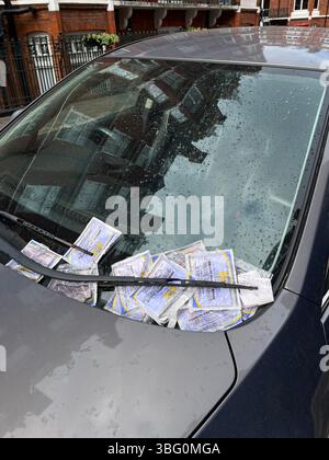 Plusieurs tickets de parking sur un pare-brise de voiture garé près de Baker Street, Marylebone London W1H 1RP UK Banque D'Images