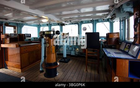 Vue intérieure du pont du navire sur le yacht royal Britannia présentant l'équipement de navigation et le mobilier en bois vintage dans un cadre maritime Banque D'Images