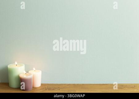 Bougies de couleur sur table en bois. Fond de mur bleu. Intérieur de la maison Banque D'Images