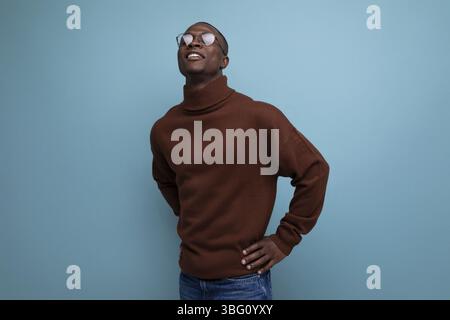 Portrait d'un jeune homme africain réussi d'apparence modèle dans un pull brun isolé avec fond d'espace copie Banque D'Images