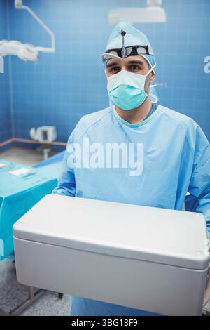 Récipient stérile en acier placé sur la table de l'instrument sous les lumières chirurgicales dans la salle d'opération bleue Banque D'Images