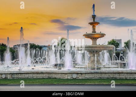 Fontaines avec coucher de soleil sur la place Unirii à Bucarest, Roumanie, Europe Banque D'Images