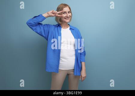 Femme mature joyeuse dans une image attrayante sur un fond bleu avec espace de copie Banque D'Images