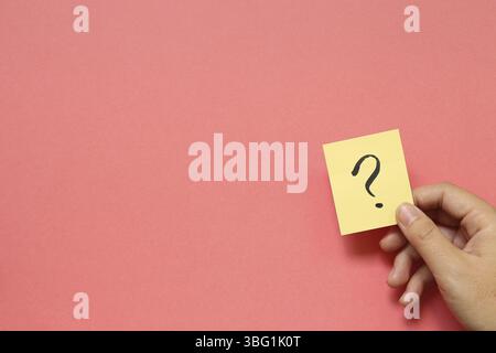 Point d'interrogation sur memo sur fond rose. Concept de la solution Banque D'Images