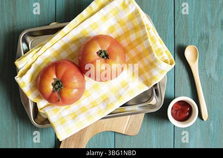 Les tomates fraîches et le ketchup sur style vintage table en bois peint en vert Banque D'Images
