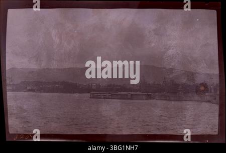 Une vue sur le lac de Zurich avec des montagnes en arrière-plan et des bains publics bordant le rivage, comme capturé lors du voyage européen des Arrases en 1913. La photographie a été prise à l'hôtel Eden au Lac à Zurich où le couple a séjourné pendant la Convention de l'Association de l'Ecole mondiale du dimanche. Banque D'Images