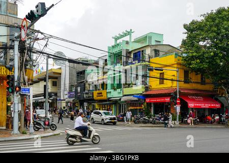 Da Nang, Vietnam-18 mars 2025 : intersection urbaine au Vietnam avec vitrines colorées, Street Cafe, motos et circulation piétonne très fréquentée Banque D'Images