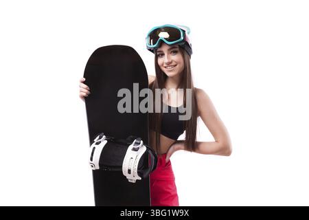 Isolé sur blanc, brune jolie jeune femme caucasienne en débardeur court noir tenir le snowboard noir Banque D'Images