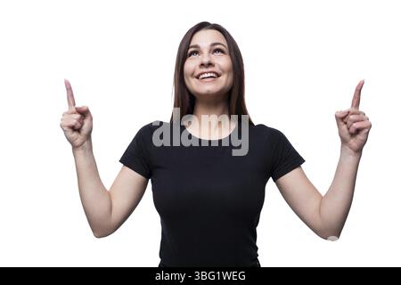 Jeune femme confiante avec les cheveux noirs vêtue d'un T-shirt noir montre ses mains vers le haut Banque D'Images