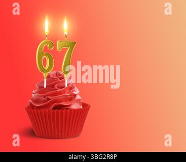 Délicieux cupcake avec des bougies en forme de nombre brûlant sur fond rouge dégradé, espace pour le texte. 67e anniversaire ou autre occasion spéciale Banque D'Images