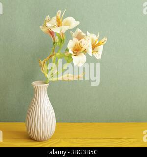 Vase de fleurs jaunes Alstroemeria sur table en bois. Fond vert Banque D'Images