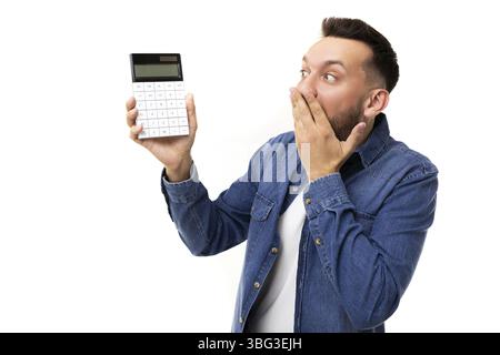 Homme charismatique d'âge moyen barbu tenant une calculatrice sur fond blanc Banque D'Images