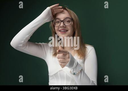 Une femme portant des lunettes et une chemise blanche est représentée dans ce cliché candide. Elle semble confiante et concentrée alors qu'elle passe sa journée Banque D'Images