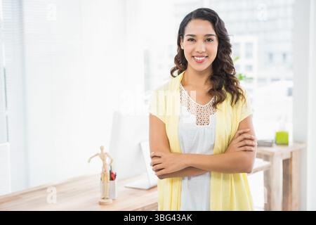 Bureau en bois tenant un moniteur d'ordinateur et plante en pot près des fenêtres remplissant le bureau de lumière Banque D'Images