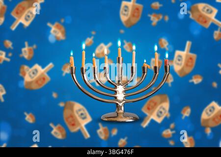 Channukah Menorah et de multiples dreidels lévitant aléatoirement sur fond bleu Banque D'Images