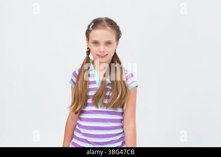 Fille debout dans le studio portant des tresses latérales pastel-clip et un polo rayé menthe lavande Banque D'Images