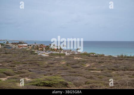 Vue côtière d'Arashi bach Aruba avec une gratte-ciel hôtelso en arrière-plan Banque D'Images