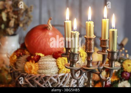 Un chandelier à l'ancienne avec des bougies dorées au milieu des décorations de table d'automne. Décor de fête Banque D'Images