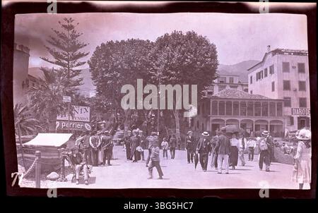 Cette photographie de 1913 montre des piétons marchant le long du port à Funchal, Madère. L'avenue Zarco mène en montée dans la ville, et le palais São Lourenço est visible sur la gauche. Cette image a été capturée par Edmund F. Arras lors de sa tournée européenne de 1913, documentant diverses villes européennes qui seront plus tard touchées par la première Guerre mondiale Banque D'Images