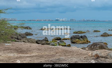 Vue côtière d'Arashi bach Aruba avec une gratte-ciel hôtelso en arrière-plan Banque D'Images