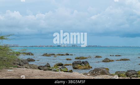 Vue côtière d'Arashi bach Aruba avec une gratte-ciel hôtelso en arrière-plan Banque D'Images