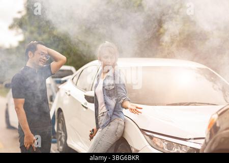 Les gens accident de voiture a brisé la fumée du moteur, les femmes folles avec le conducteur de l'homme en colère bouleversé et ennuyeux, surchauffe du moteur dans le voyage d'été Banque D'Images