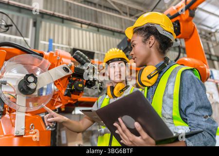 formation d'ingénieur robotique, travail de technicien dans l'opérateur de contrôle de machine de bras de soudage de robot industriel moderne d'usine Banque D'Images