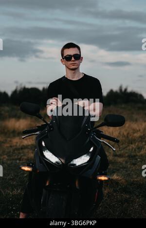 Portrait d'un motard masculin dans un casque à une moto sportive Banque D'Images