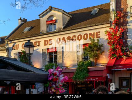 Les gens regardent au sommet de Montmartre autour de la place du Tertre. Avec des touristes buvant ou mangeant dehors, profitant de la vie parisienne. Banque D'Images
