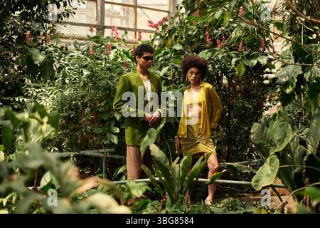 Un couple aimant profite d'un moment tendre au milieu d'une collection florissante de plantes dans une serre. Banque D'Images