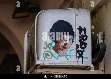 Graffiti et Amélie sur un climatiseur extérieur, avec des motifs abstraits colorés et du texte noir. Banque D'Images