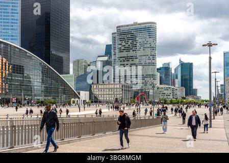 Des gens pendant le déjeuner à la Défense avec des gratte-ciel en arrière-plan. La Défense est le plus grand quartier d'affaires d'Europe construit à cet effet Banque D'Images