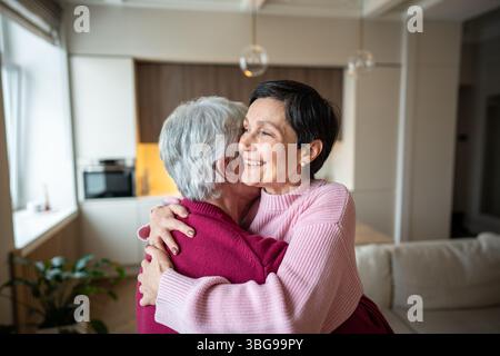 Joyeux couple sénior heureux célébrant la réussite. Femme heureuse dans les bras, promotion récupération Banque D'Images