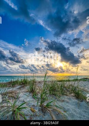 Coucher de soleil avec des nuages spectaculaires dans le ciel au-dessus du golfe du Mexique près de la jetée de pêche de Venise à Venice Florida USA Banque D'Images
