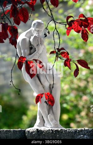 Château de Bory, Székesfehérvár, Hongrie - mai 31 2025 : sculpture romantique par Jenő Bory d'un couple embrassant entouré de feuilles rouges en format vertical Banque D'Images