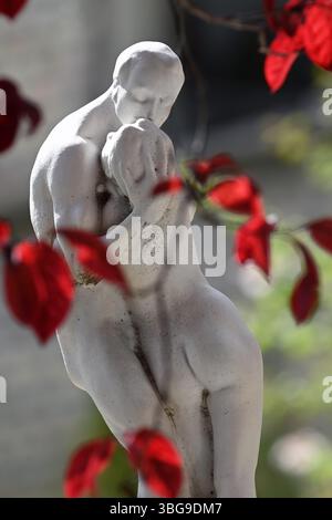 Château de Bory, Székesfehérvár, Hongrie - mai 31 2025 : sculpture romantique par Jenő Bory d'un couple embrassant entouré de feuilles rouges en format vertical Banque D'Images
