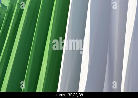 Résumé du drapeau national fait de morceaux géants de tissu de couleurs vertes et blanches exposées extérieurement. Couleurs vives et éclatantes. Lumière du soleil et ombres Banque D'Images