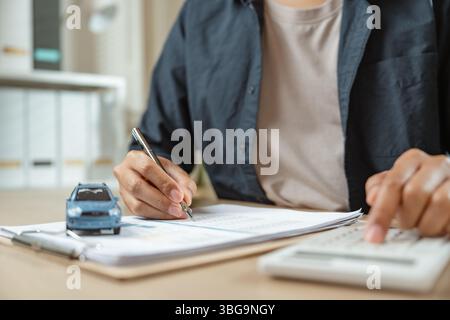 Homme signant l'assurance automobile sur l'assurance papier. Achat ou vente d'un véhicule neuf. Propriété pour voiture neuve ou concept de location. Banque D'Images