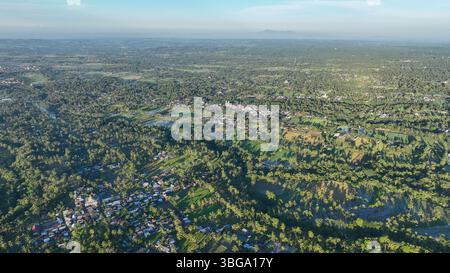 Surplombant le paysage tropical de Lombok, cette photo aérienne révèle des rizières sans fin, des villages dispersés et des sommets volcaniques lointains sous un vibran Banque D'Images