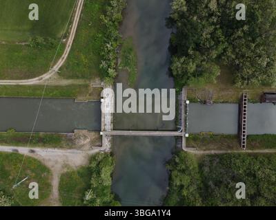 Large vue par drone du Canale Cavour tissant à travers la campagne de Novara, vitale pour le vaste réseau d’irrigation agricole du Piémont. Banque D'Images