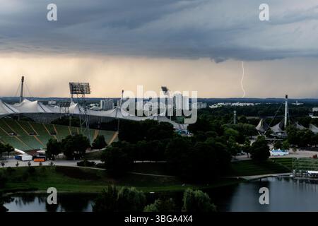 Munich, Allemagne. 04 juin 2025. Un éclair peut être vu dans le ciel au nord de Munich derrière le stade olympique. Crédit : Matthias Balk/dpa/Alamy Live News Banque D'Images