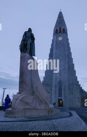 Hallgrimskirkja, avec sa flèche imposante, domine l'horizon de Reykjavik. Son design moderniste, tour de l'église avec horloge après le coucher du soleil Banque D'Images