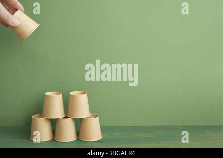 Pile pyramidale de tasse brune sur table en bois. arrière-plan vert. développement de l'entreprise concept de croissance de la réalisation Banque D'Images