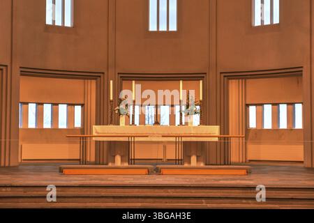 Hallgrimskirkja, avec sa flèche imposante, domine l'horizon de Reykjavik. Son design moderniste, l'intérieur de l'église dans une lumière jaune chaude Banque D'Images