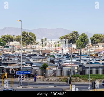 Bidonville du tiers monde dans la rue Icola, zone Khayelitsha à la périphérie de Cape Town avec des maisons et des cabanes en panneaux de fer ondulé. Banque D'Images