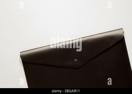 Dossier d'affaires noir avec un bouton comme fond pour les thèmes d'affaires sur un fond blanc, les documents et le travail de bureau Banque D'Images